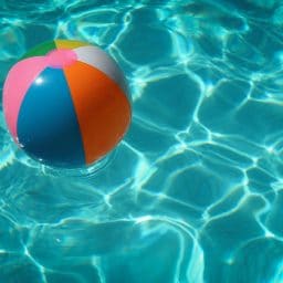 A beach ball floating in a pool.
