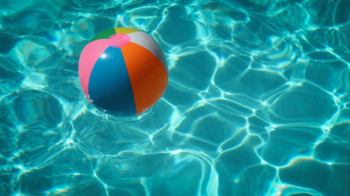 A beach ball floating in a pool.