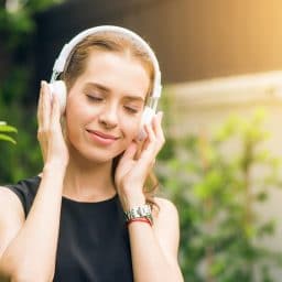 Woman wearing headphones and happily listening to music.