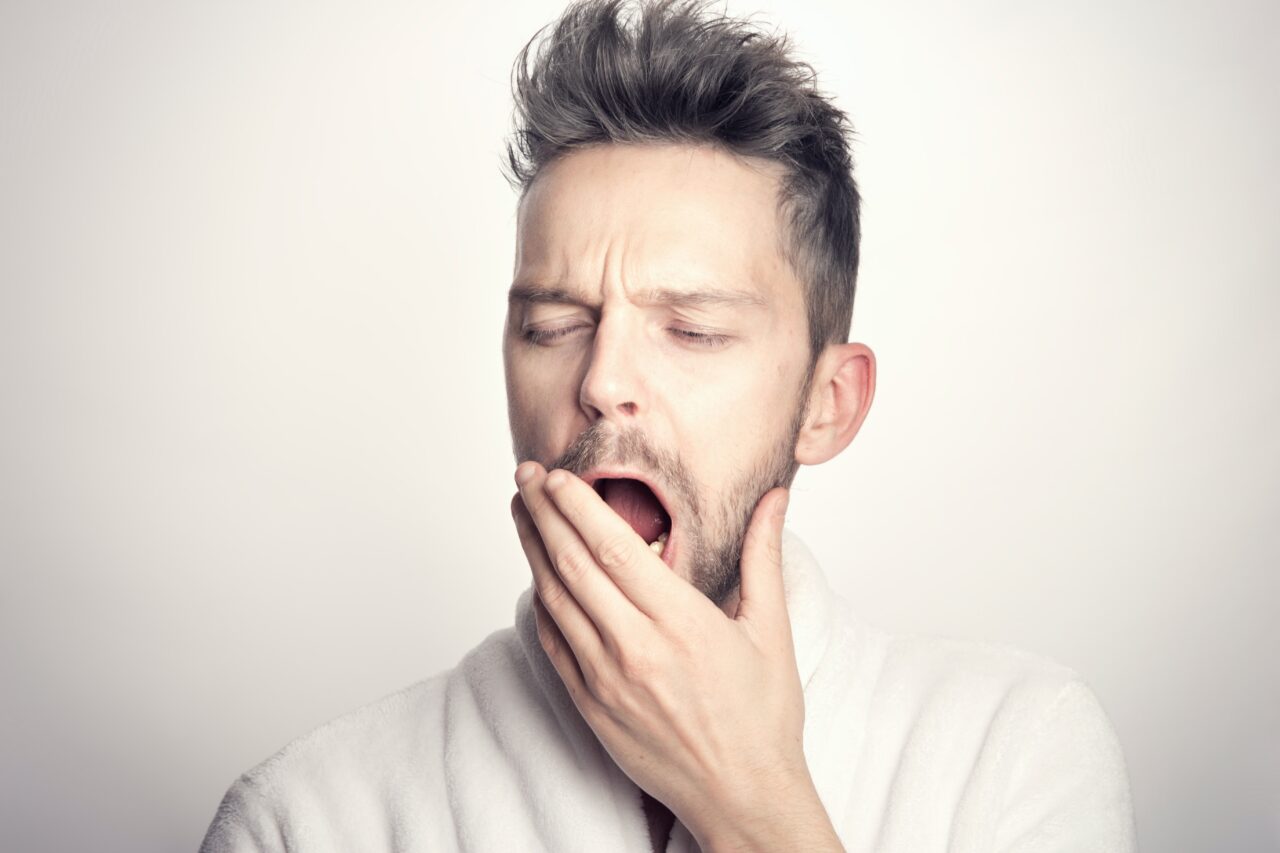 Man yawning in front of a white background.